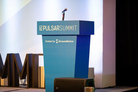 Picture of the open podium with a microphone and "Pulsar Summit, hosted by StreamNative" on the front of the podium.
